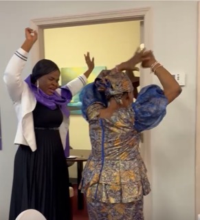 Two women praising together in sisterhood at the R.I.S.E. Women's Retreat