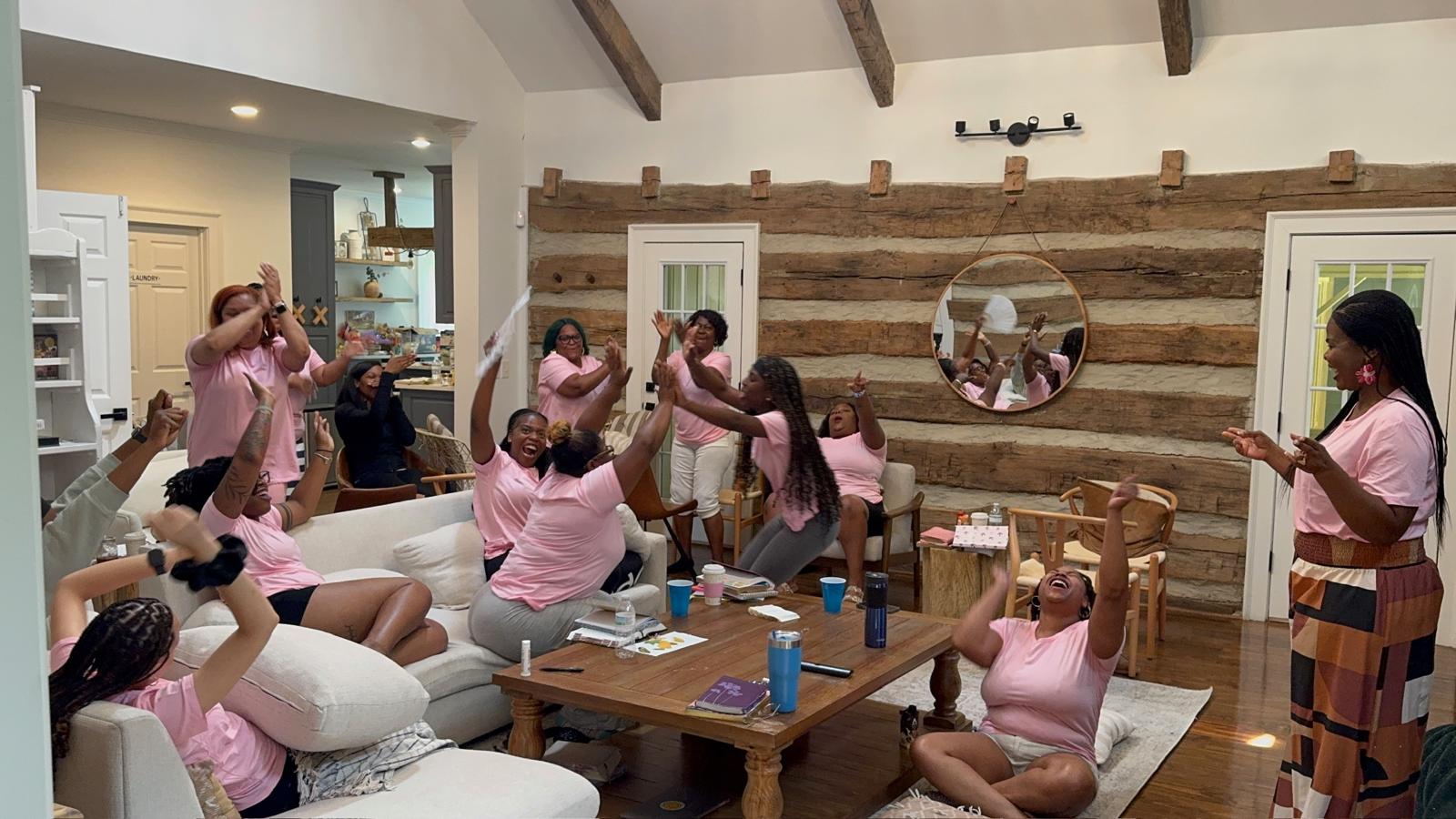 Women worshipping with hands raised at the R.I.S.E. Women's Retreat